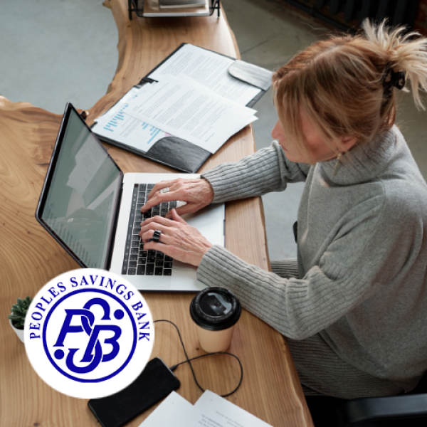 Woman typing on laptop while seated at desk preparing her business financials