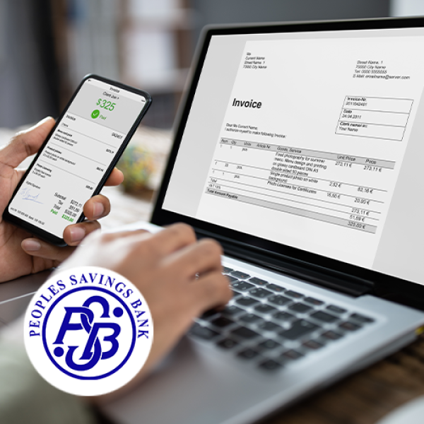 Business owner looking at invoice and financial information on smartphone and laptop