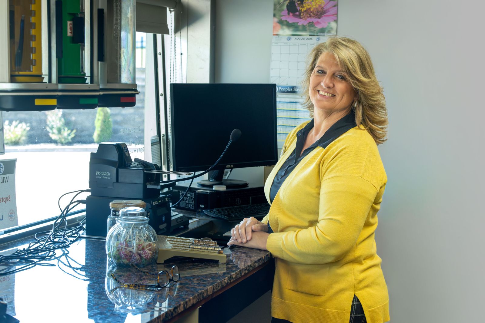 PSB Bank employee smiling at a teller station inside a bank branch.