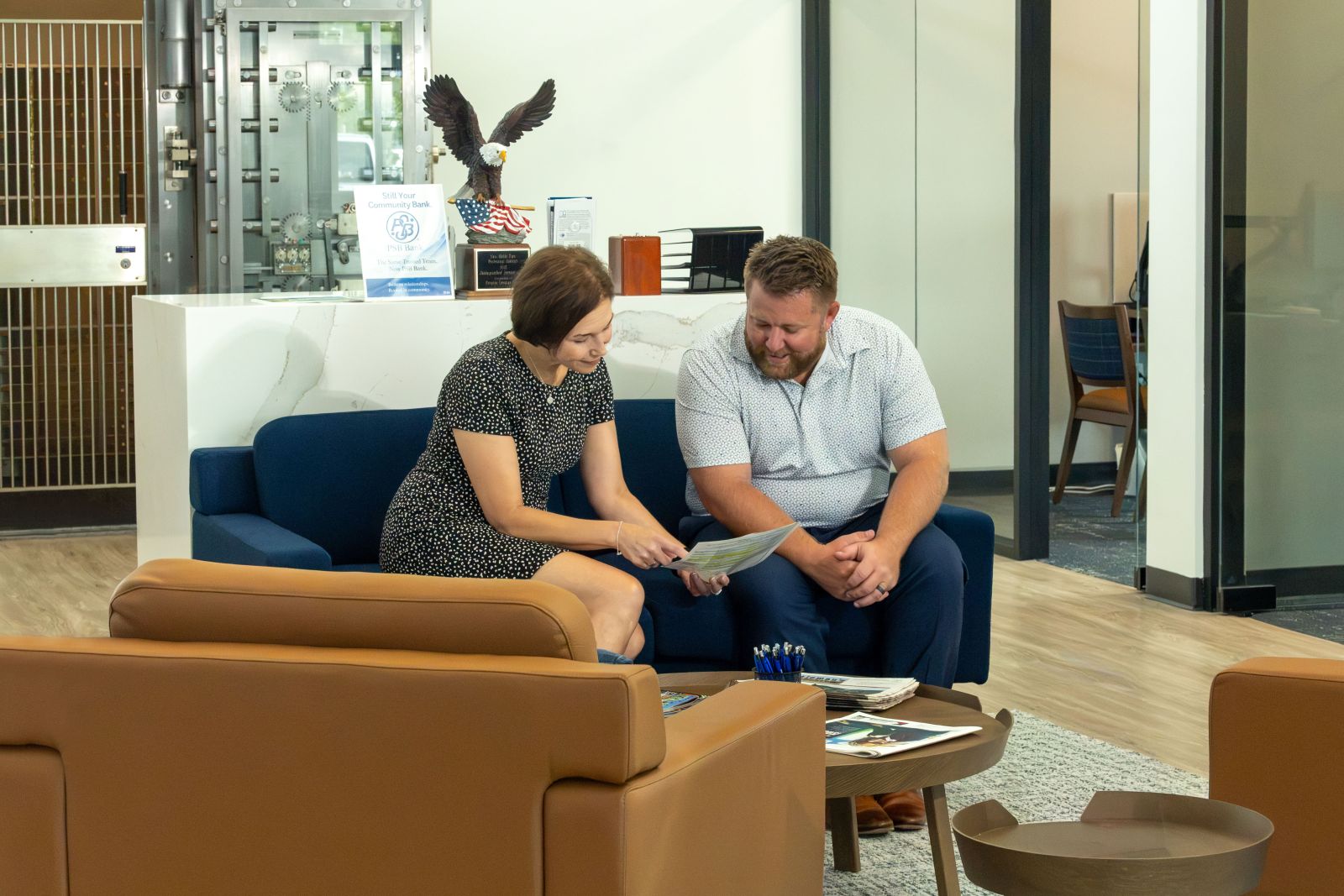 PSB Bank employee reviewing a document with a customer in the lobby of a bank branch.