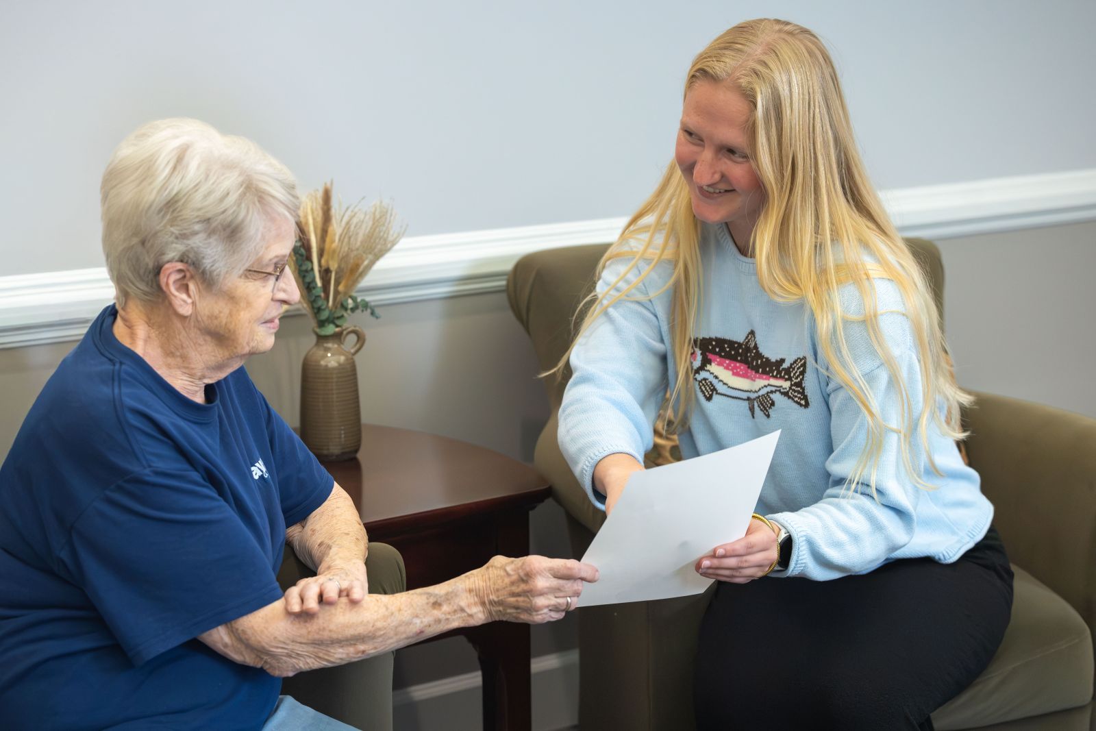 PSB Bank employee reviewing a document with an older customer during a meeting at a bank branch.