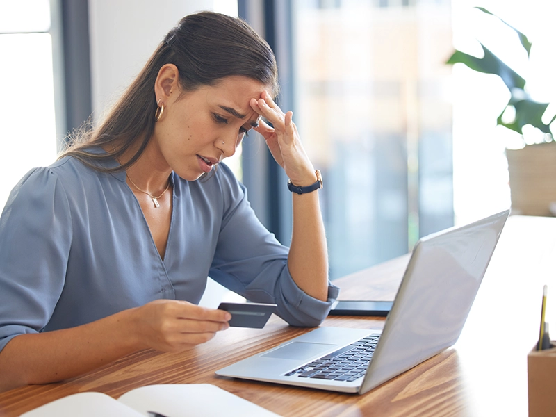 stressed woman holding debit card
