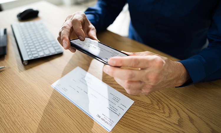Image of person taking photo of check using mobile deposit Image of person taking photo of check using mobile deposit